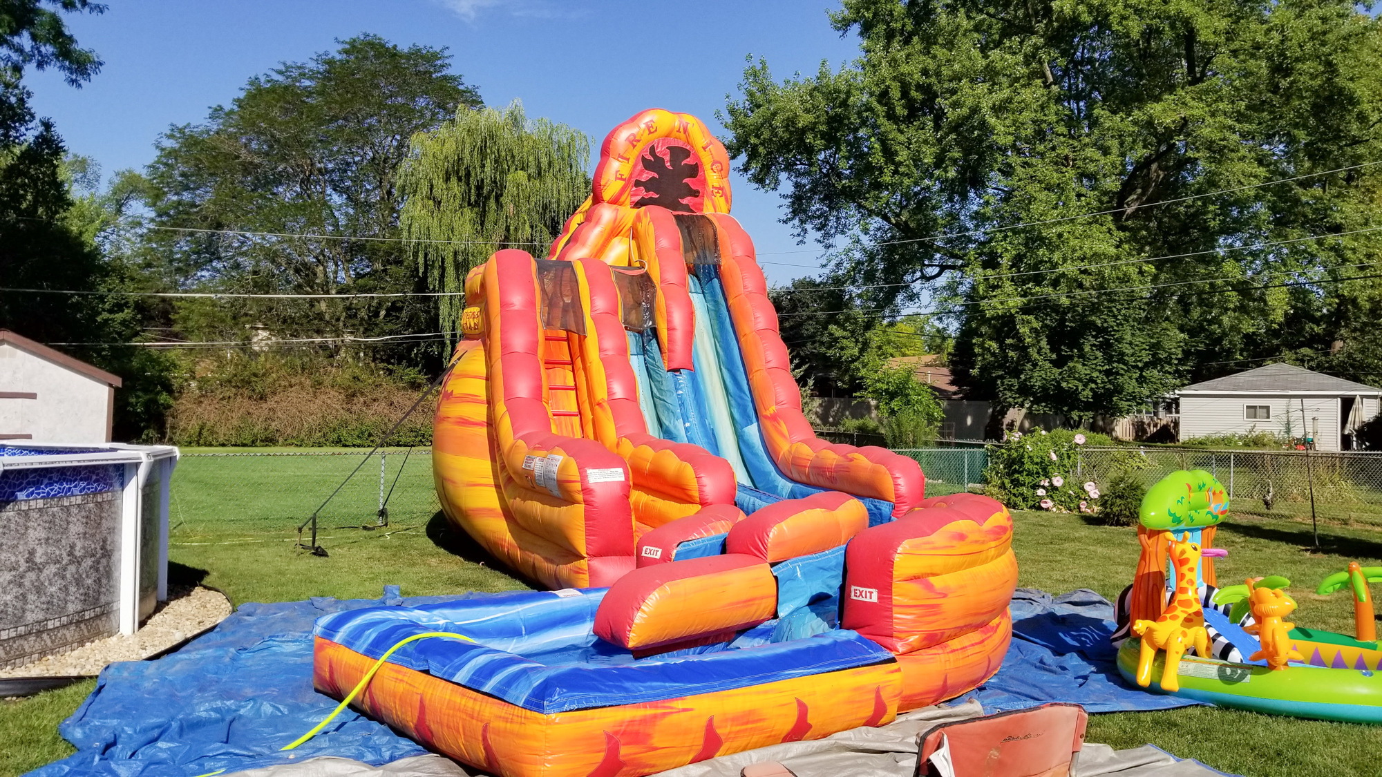 Fire n' ice inflatable water slide in a backyard on a sunny day.