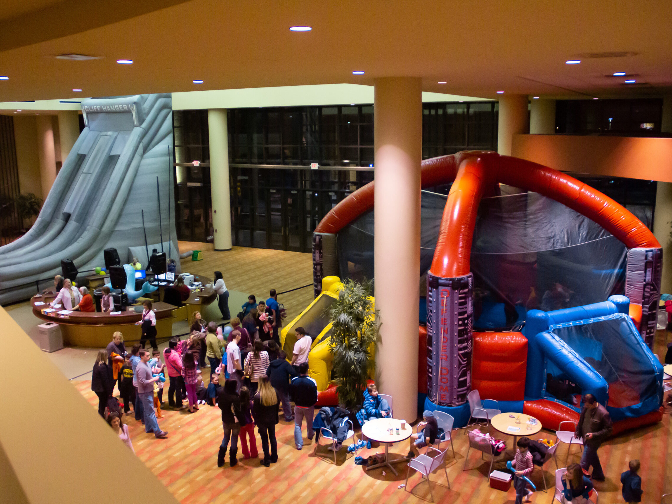 Overhead view of people inside a building talking and waiting in line to go into an inflatable soccer dome.