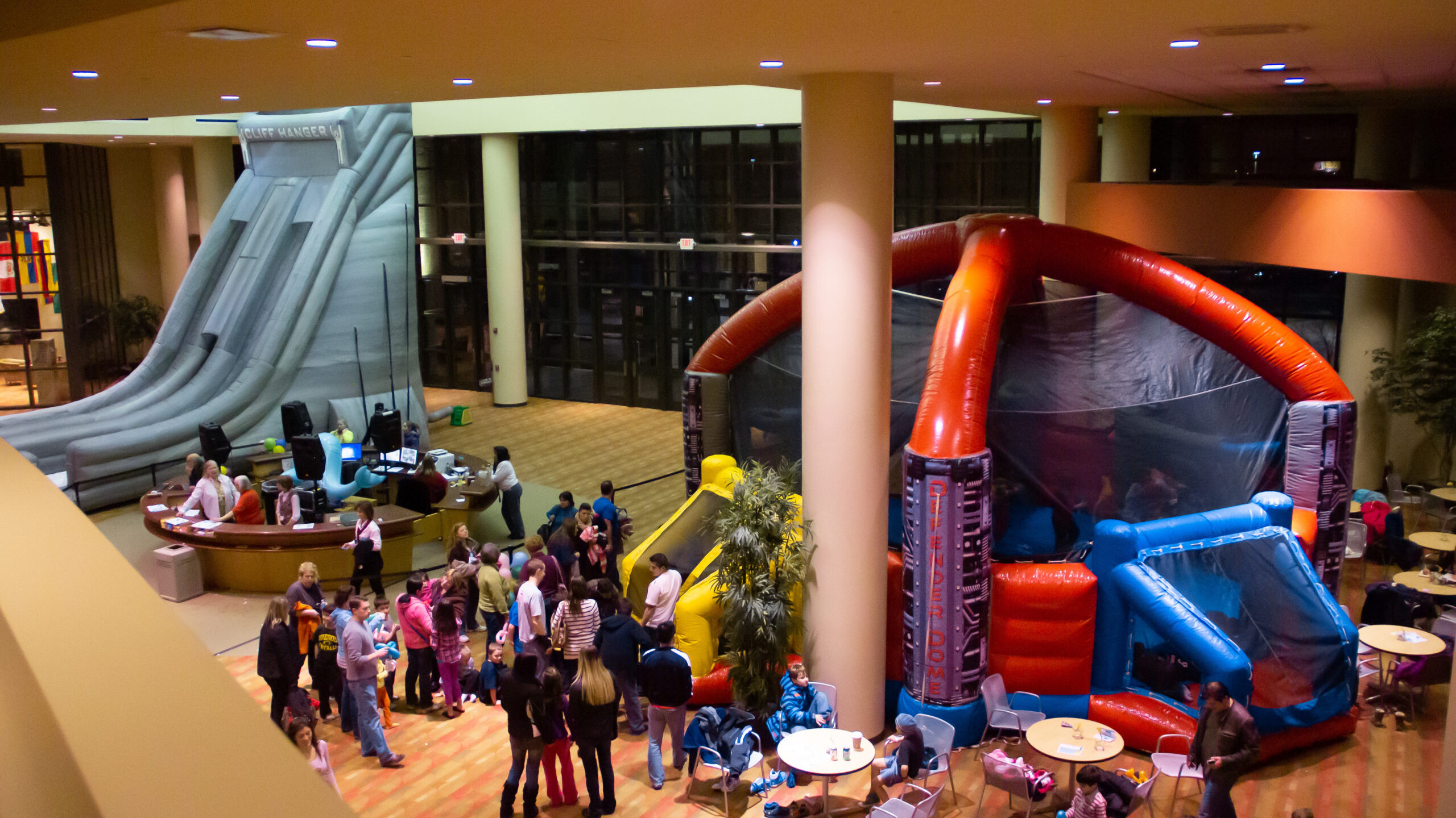 Overhead view of people inside a building talking and waiting in line to go into an inflatable soccer dome.