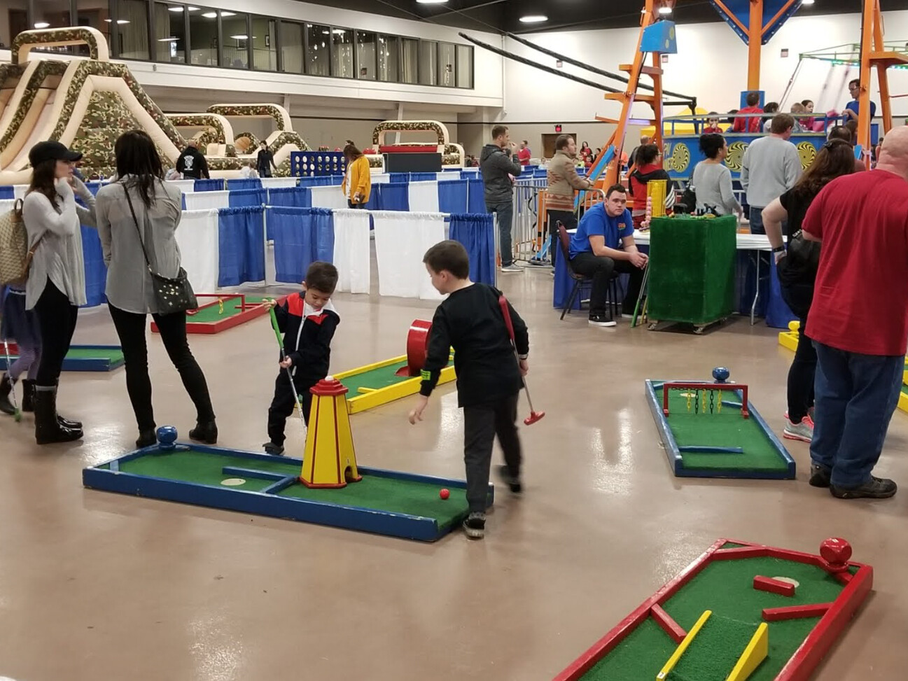 Kids and adults playing mini golf at the family fun fest in Chicago.
