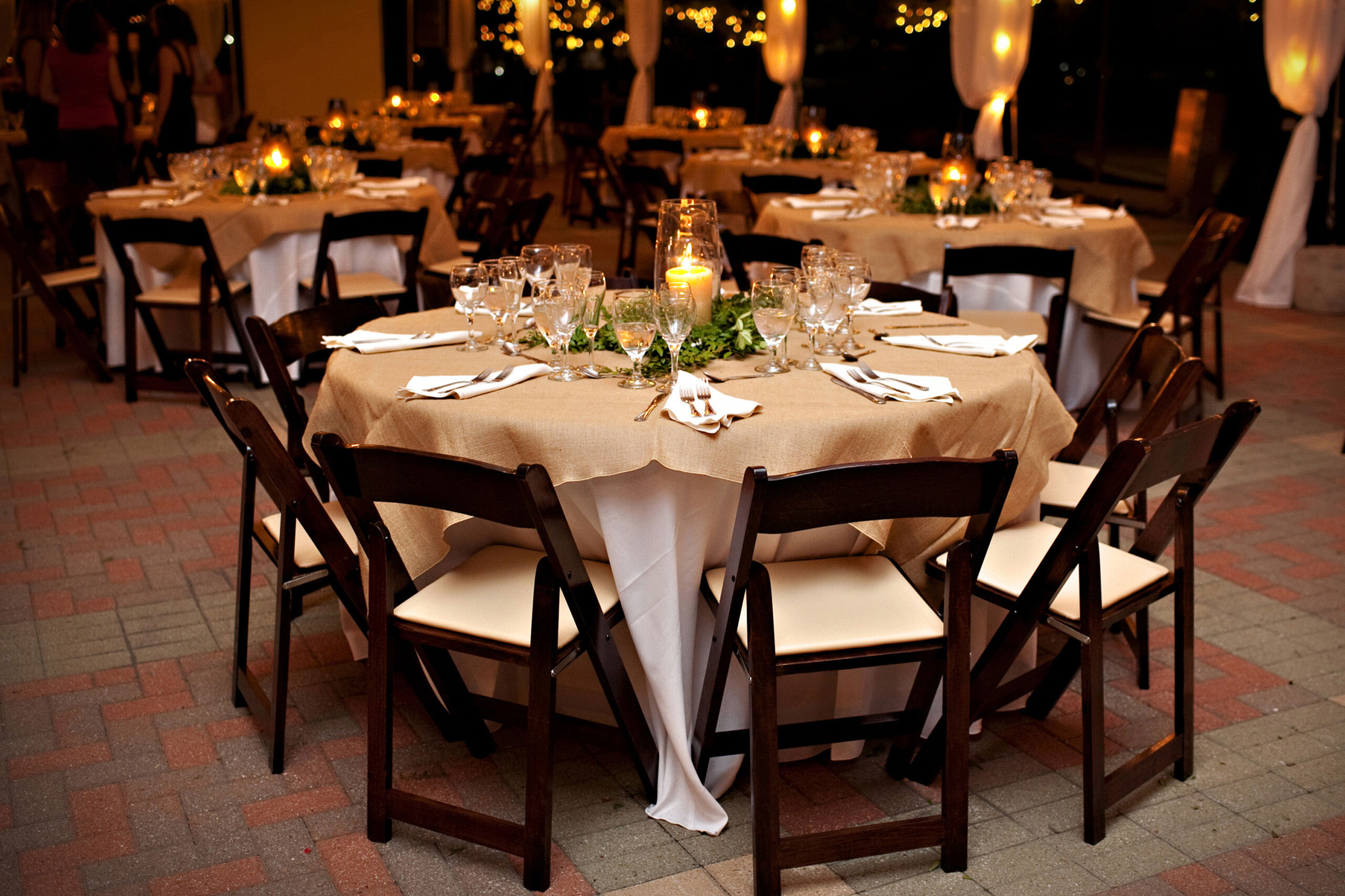 Candel lit tables and chairs set for a wedding dinner.