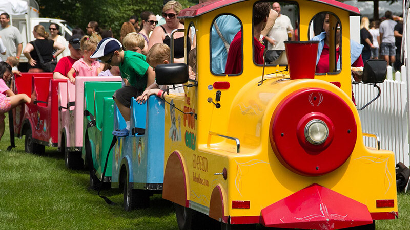 Kids hopping off a trackless train rental at a festival in Chicago.